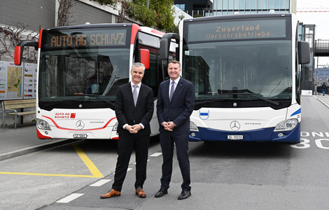 Zwei Busfahrer vor den Bussen