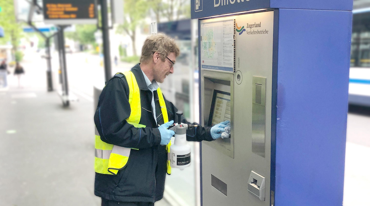 Mann putzt Billettautomaten