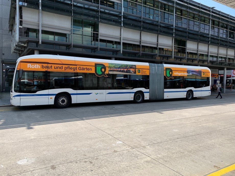 Das Bild zeigt einen Bus mit Dachlängswerbung