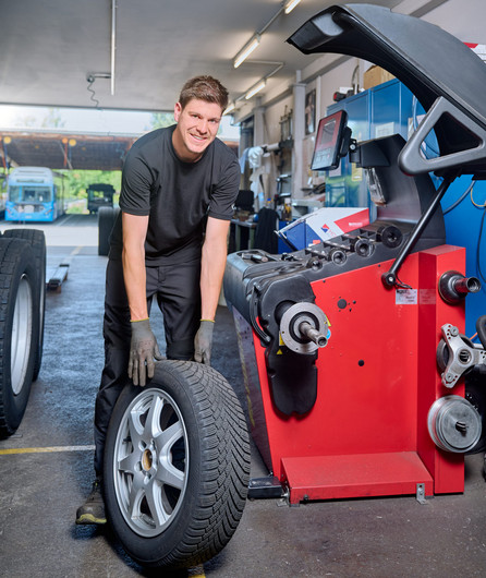 Auf dem Bild ist ein Mitarbeiter der Autowerkstatt bei seiner Tätigkeit zu sehen