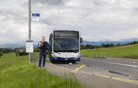 Fahrgast stehend neben Bus