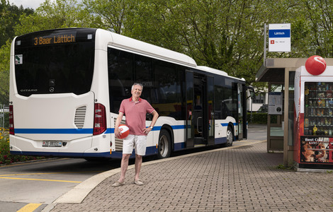 Fahrgast stehend neben Bus